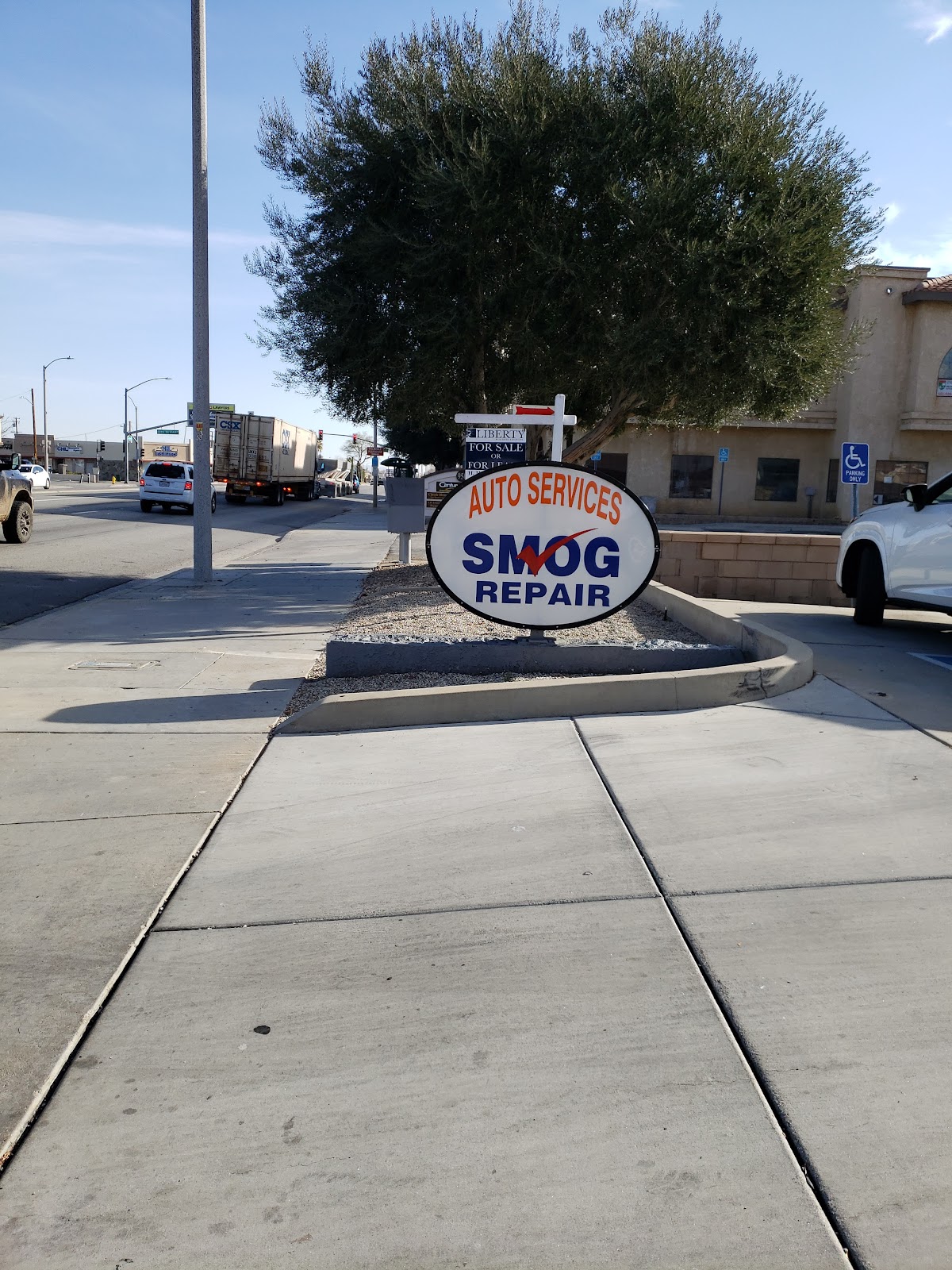 The Palmdale Auto Services sign on East Palmdale Boulevard reading Auto Services, Smog, Repair
