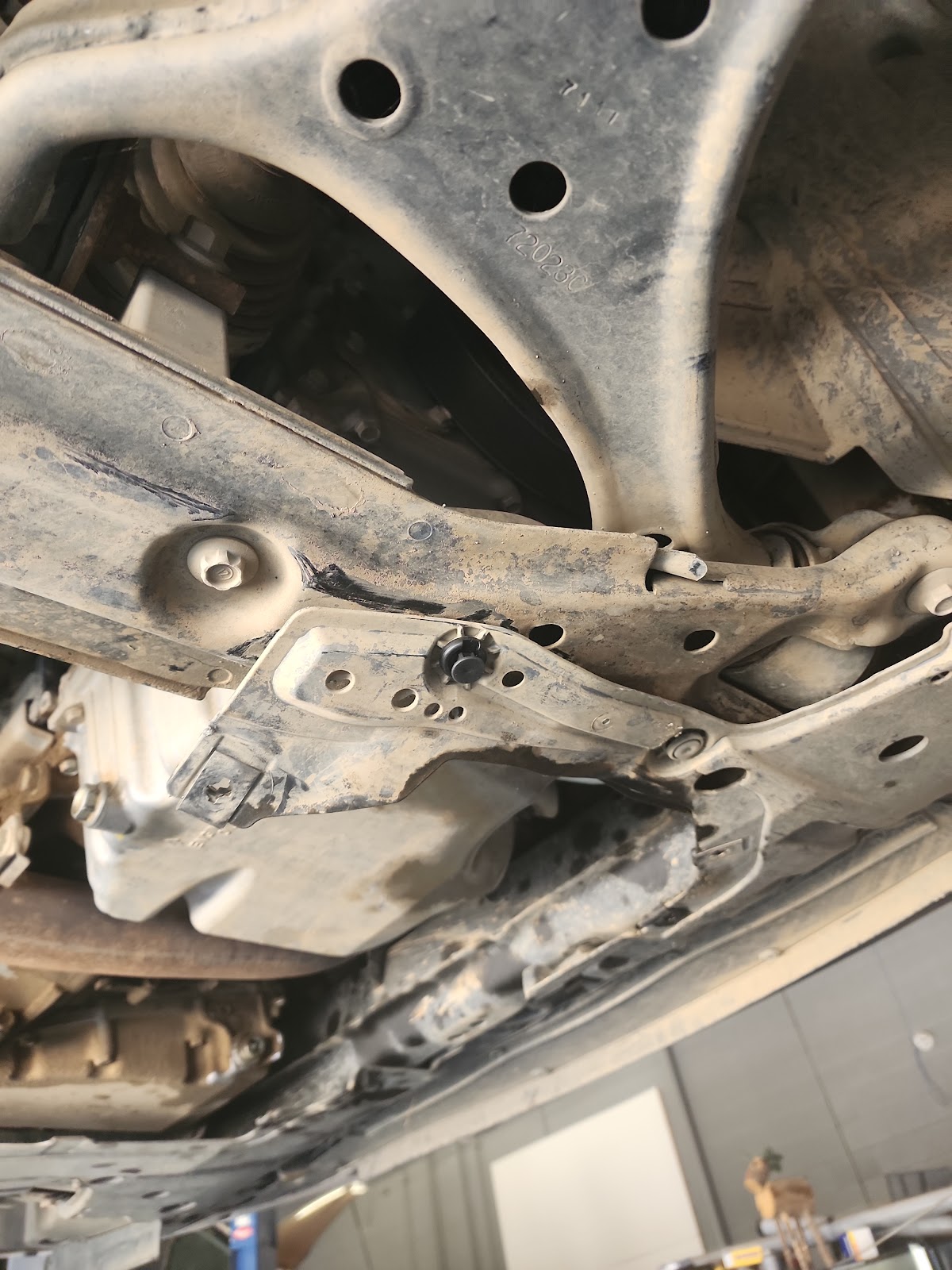 A vehicle raised on the lift at Palmdale Auto Services, underbody and suspension visible